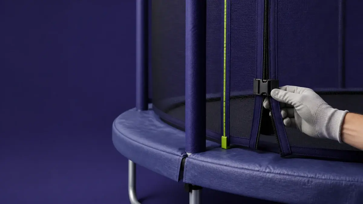 Handske kontrollerer spænde og lynlås ved sikkerhedsnettet på en havetrampolin